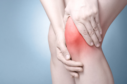 A young woman massaging her painful knee